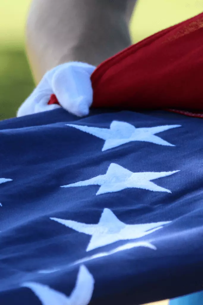 Member of military folding American flag at funeral